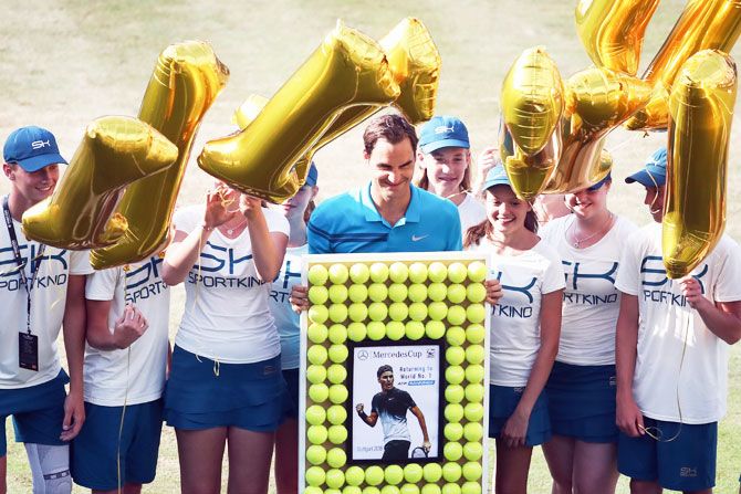 Switzerland's Roger Federer poses with ball kids after defeating Australia's Nick Kyrgios and returning to the top position in the ATP global rankings on Day 6 of the Mercedes Cup at Tennis club Weissenhof in Stuttgart on Saturday