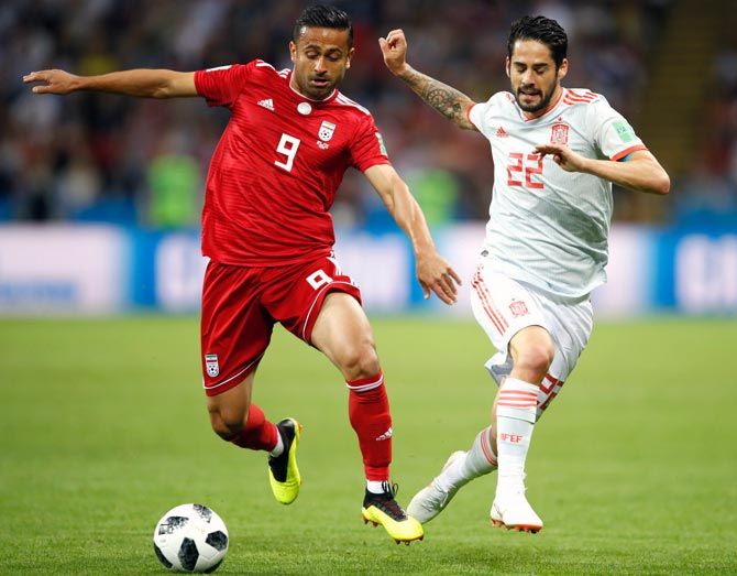 Spain’s Isco battles for the ball with Omid Ebrahimi of Iran