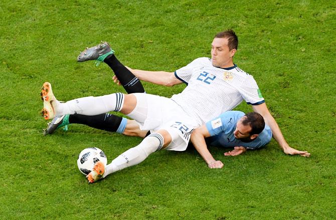 Uruguay's Diego Godin and Russia's Artem Dzyuba go down as they vie for possession