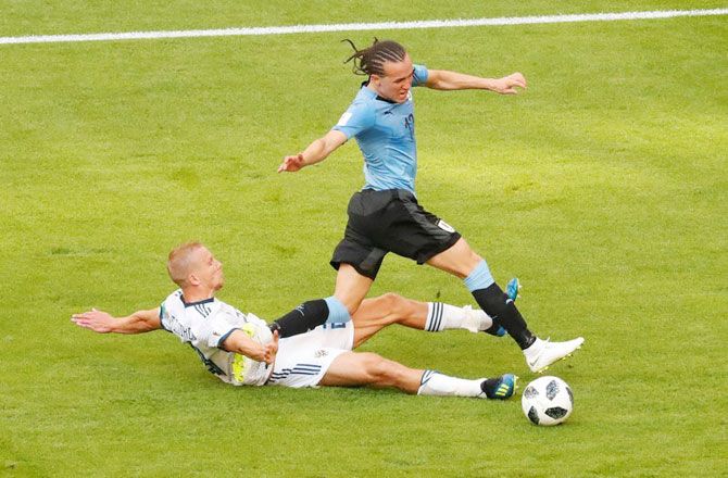 Russia's Igor Smolnikov fouls Uruguay's Diego Laxalt 
