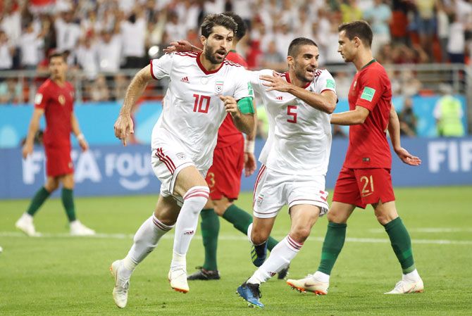 Iran's Karim Ansarifard celebrates with teammate Milad Mohammadi after scoring his team's first goal