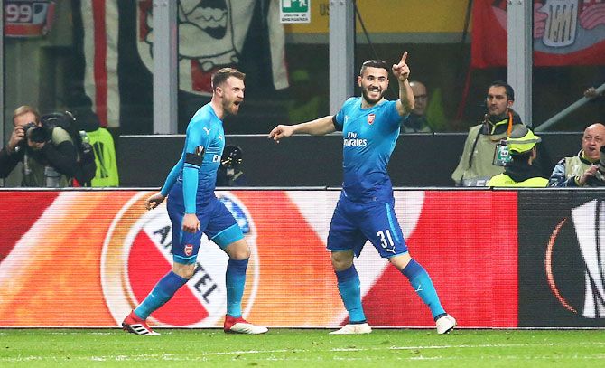 Arsenal's Aaron Ramsey celebrates with teammate Sead Kolasinac after scoring their second goal in the Europa League Round of 16 First Leg match at San Siro Stadium in Milan