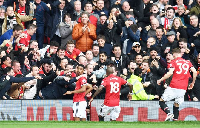 Manchester United's Marcus Rashford celebrates with fans and team mates after scoring the first goal against Liverpool during their Premier League match at Old Trafford in Manchester