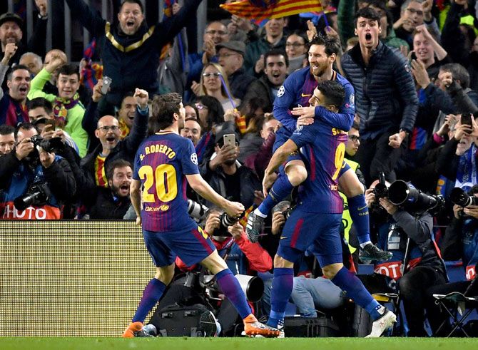 Barcelona's Lionel Messi celebrates with teammates Sergi Roberto and Luis Suarez as he scores their opening goal against Chelsea