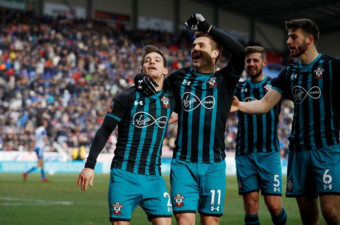 Southampton's Cedric Soares celebrates with Dusan Tadic and teammates after scoring their second goal against Wigan Athletic at DW Stadium, Wigan, on Sunday