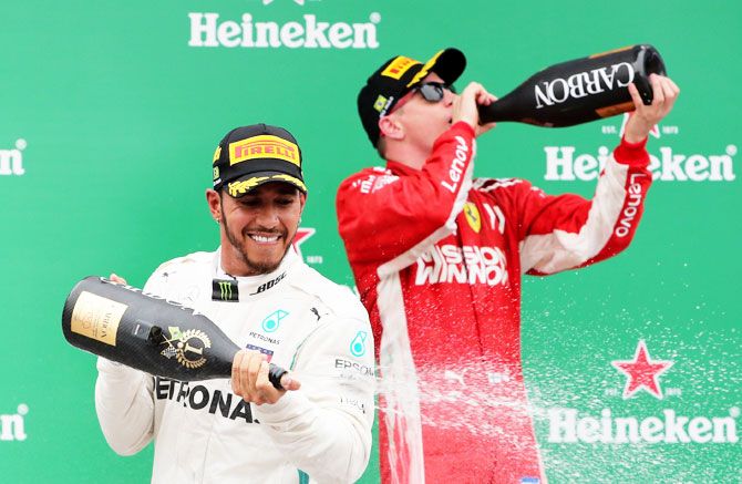 Mercedes' Lewis Hamilton celebrates on the podium with third placed Ferrari's Kimi Raikkonen