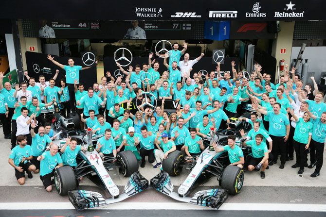 Mercedes' Lewis Hamilton, his teammate Valtteri Bottas, Executive Director Toto Wolff and team members pose after winning the constructors championship 