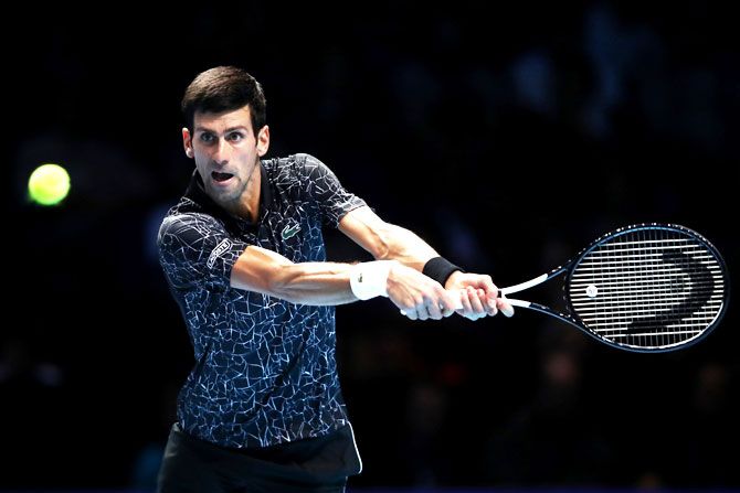 Serbia's Novak Djokovic plays a backhand during his singles round robin match against USA's John Isner on Day 2 of the ATP World Tour Finals at The O2 Arena in London on Monday