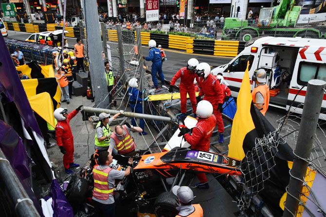 Race personnel and pit crew are seen at the accident site after Sophia Floersch, a German driver of Van Amersfoort Racing flew over the barriers and crashed into a photographers' bunker at high speed, during a Formula Three race at the Macau Grand Prix, in Macau, China, on Sunday