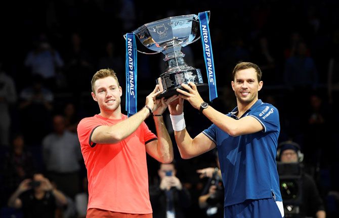Mike Bryan and Jack Sock of the US celebrate with a trophy after winning the ATP Tour Final doubles final on Sunday