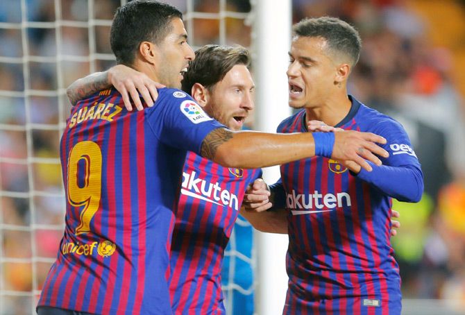 Lionel Messi, centre, celebrates scoring a goal for Barcelona with Luis Suarez, left, and Philippe Coutinho