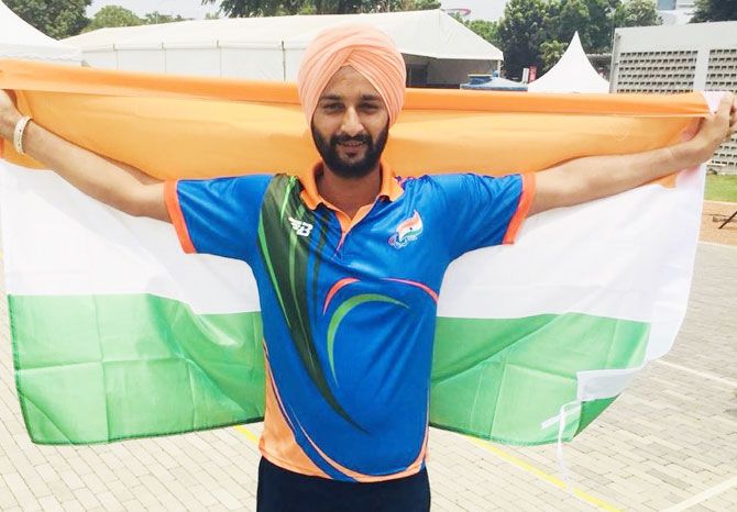 Archer Harvinder Singh celebrates with the Indian flag after winning the men's individual recurve gold in the Asian Para-Games in Jakarta on Wednesday