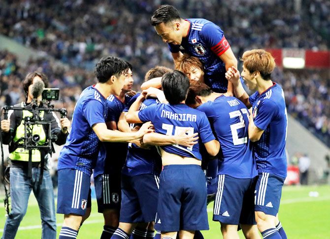 Japan's Takumi Minamino celebrates with team mates after scoring their first goal against Uruguay at the Saitama Stadium in Saitama, Japan, on Tuesday
