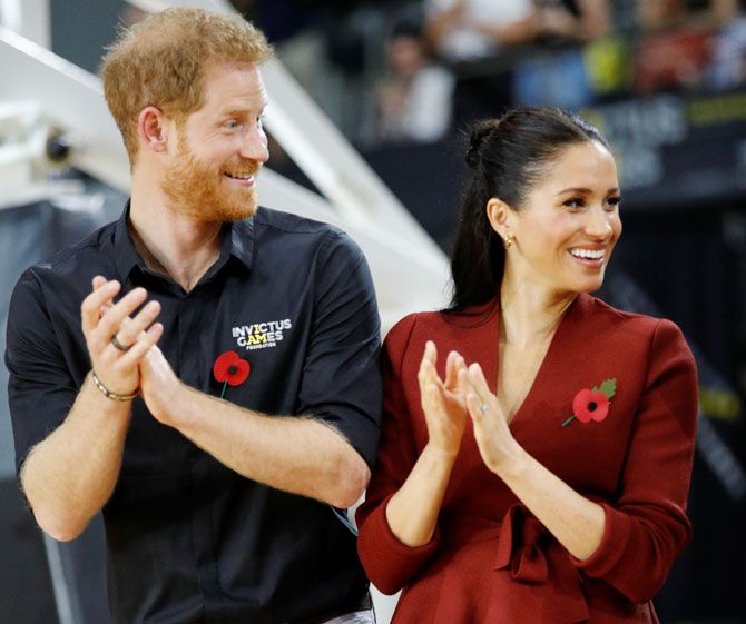 Britain's Prince Harry and Meghan, Duchess of Sussex, applaud before handing out awards to the Invictus Games Sydney 2018 wheelchair basketball medallists at Quaycentre in Sydney, Australia on Saturday