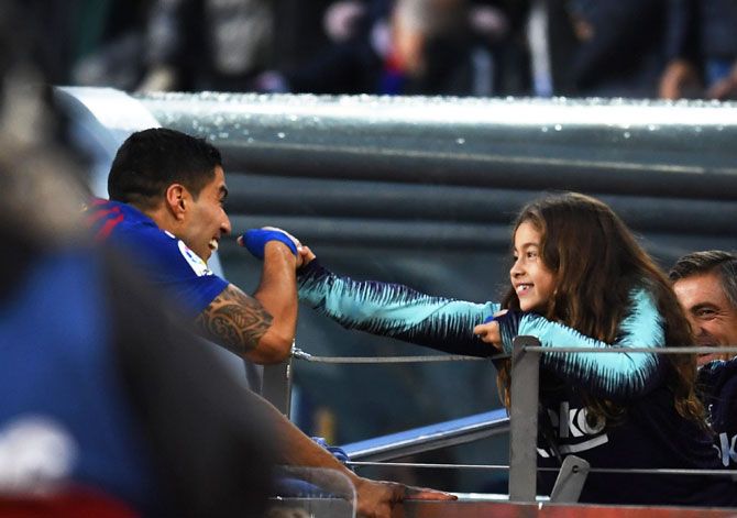 Barcelona's Luis Suarez celebrates with his daughter after their La Liga EL Clasico victory over Real Madrid CF at Camp Nou in Barcelona on Sunday