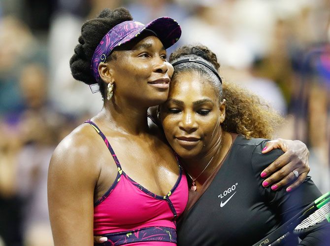 Venus and Serena hug at the net after the latter won their third round match