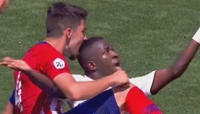 Real Madrid's Vinicius Jr gets bitten by an Atletico player during their reserve-team derby match on Sunday