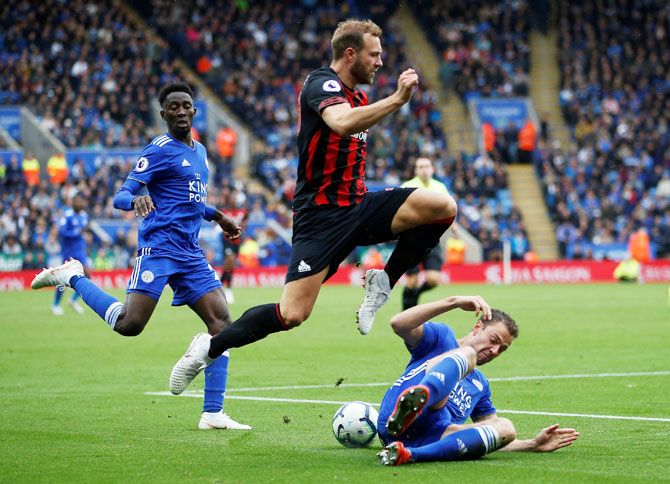 Leicester City's Jonny Evans and with Huddersfield Town's Laurent Depoitre vie for possession