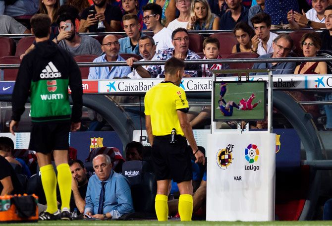 Referee Jesus Gil Manzano looks at the Video Assistant Referee VAR screen before showing a red card to FC Barcelona's Clement Lenglet during the La Liga match between FC Barcelona and Girona FC at Camp Nou in Barcelona on Sunday