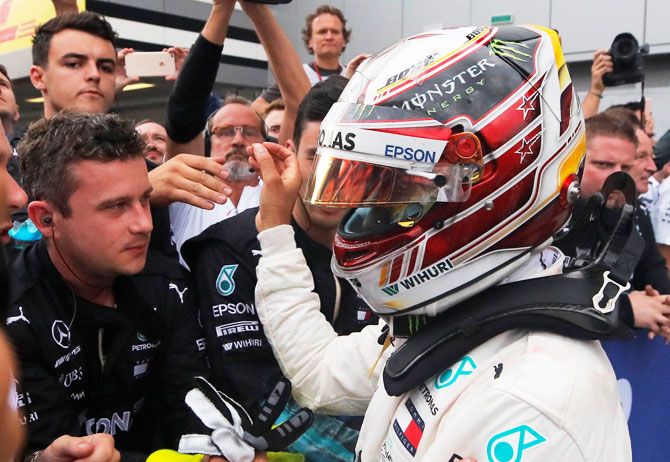 Lewis Hamilton celebrates with his team after winning the race