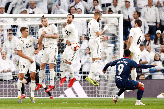 Huesca's Cucho Hernandez shoots a free-kick against Real Madrid's defensive wall