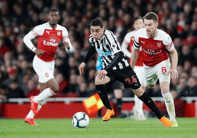 Newcastle United's Miguel Almiron dribbles past Arsenal's Aaron Ramsey