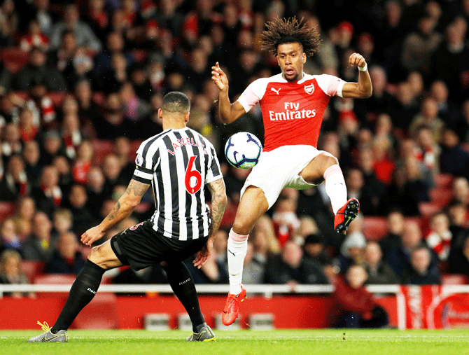 Arsenal's Alex Iwobi and Newcastle United's Jamaal Lascelles vie for possession