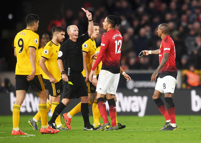 Manchester United's Ashley Young is shown the red card by referee Mike Dean