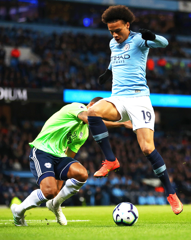Manchester City's Leroy Sane is challenged by Cardiff City's Lee Peltier