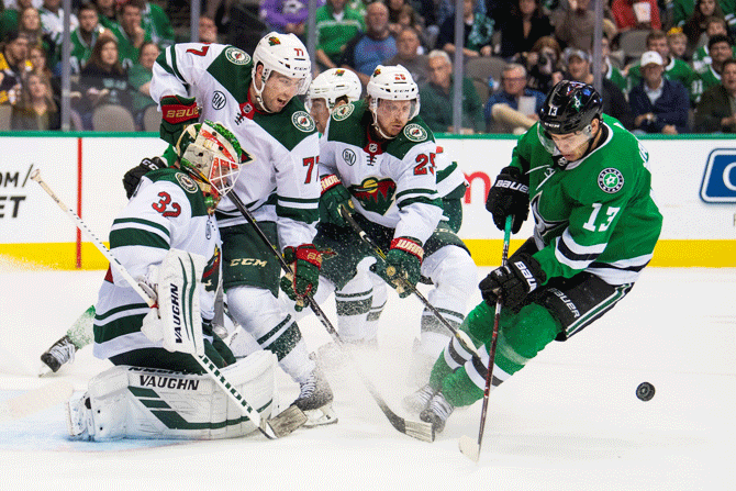 Minnesota Wild goaltender Alex Stalock (32) and defenseman Brad Hunt (77) and defenseman Jonas Brodin (25) defend the goal against Dallas Stars center Mattias Janmark (13) during the second period of their ice hockey match at the American Airlines Center in Dallas, Texas, on Saturday, April 6