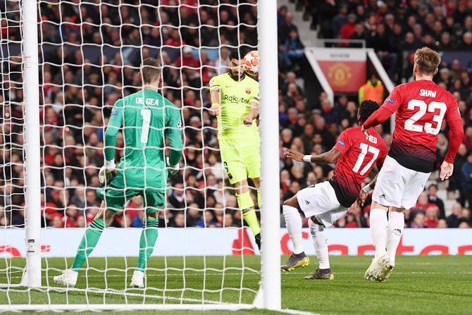 Barcelona's heads the ball that deflects off Manchester United's Luke Shaw (not in picture) for an own goal by Shaw during their match at Old Trafford in Manchester