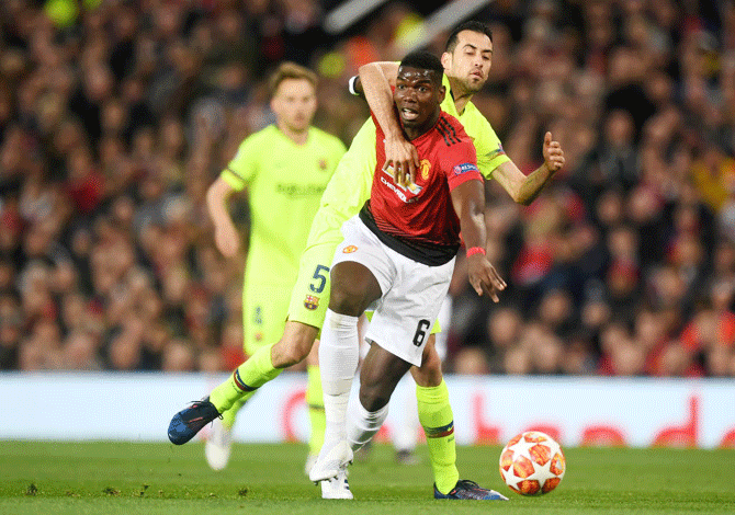 Manchester United's Paul Pogba is challenged by Barcelona's Sergio Busquets