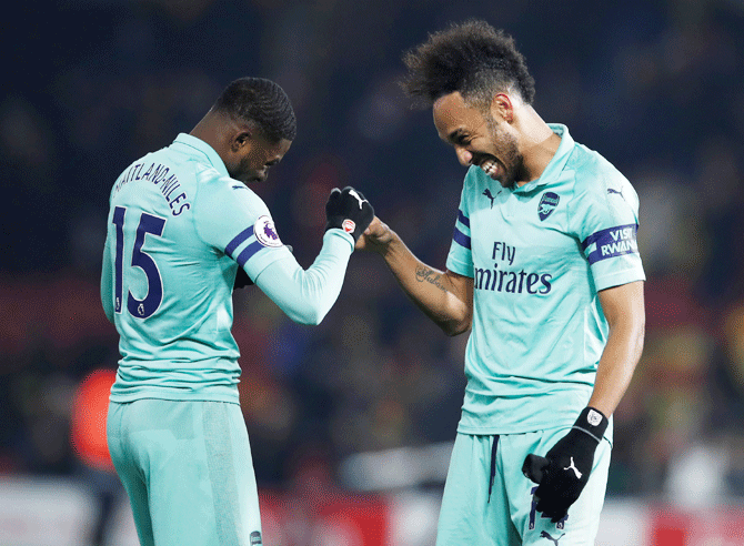 Arsenal's Pierre-Emerick Aubameyang and Ainsley Maitland-Niles celebrate after the match against Watford at Vicarage Road, Watford, on Monday