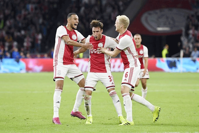 Ajax players celebrate a goal against POAK to register a 3-2 win to progress