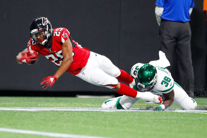 Atlanta Falcons' Ito Smith is tackled by New York Jets' Doug Middleton during the first half of an NFL preseason game at Mercedes-Benz Stadium in Atlanta, Georgia on Thursday, August 15