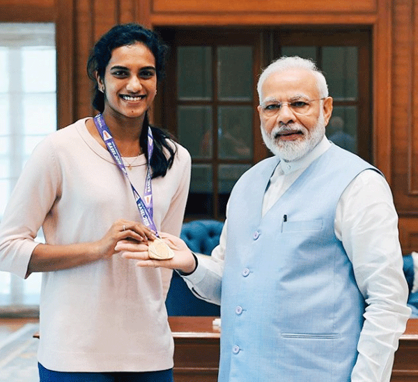 World Champion PV Sindhu shows her medal as she poses alongside PM Narendra Damodardas Modi in New Delhi on Tuesday