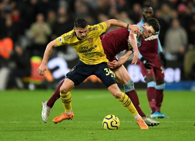 Arsenal's Granit Xhaka is challenged by West Ham United's Declan Rice