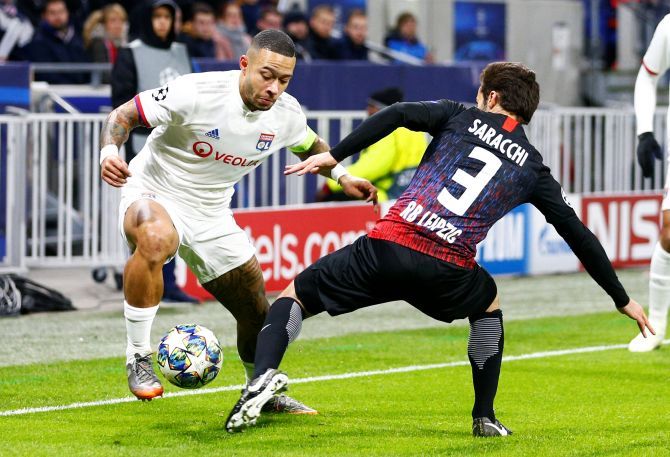 Olympique Lyonnais' Memphis Depay and with RB Leipzig's Marcelo Saracchi vie for possession during their Champions League Group G match at Groupama Stadium, Lyon, France