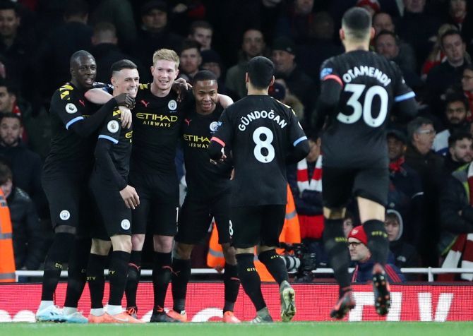 Manchester City's Kevin De Bruyne celebrates scoring their third goal with teammates during their EPL match against Arsenal at the Emirates Stadium in London