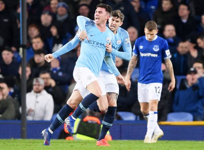 Manchester City's Aymeric Laporte celebrates with teammate John Stones after scoring the opening goal during their match against Everton FC at Goodison Park in Liverpool