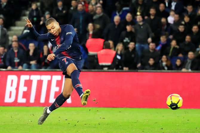 Paris St Germain's Kylian Mbappe scores their third goal against Nimes Olympique during their Ligue 1 match at Parc des Princes stadium in Paris on Saturday