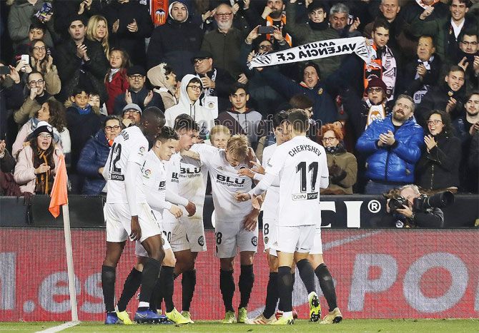 Valencia players celebrate a goal against Sporting Gijon on Tuesday