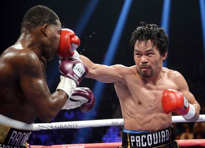 Manny Pacquiao, right, lands a punch on Adrien Broner