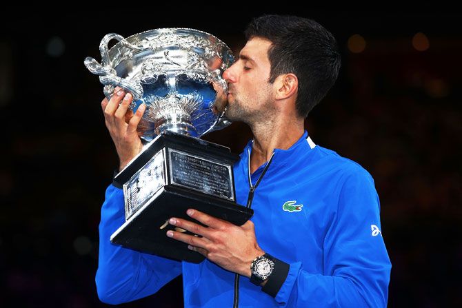 Serbia's Novak Djokovic kisses the Norman Brookes Challenge Cup following victory in the Australian Open men's singles final against Spain's Rafael Nadal at Melbourne Park on Sunday