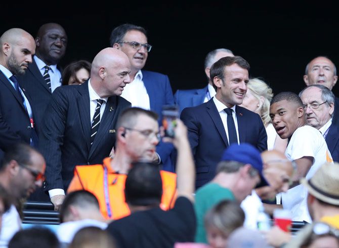 Emmanuel Macron, President of France, Gianni Infantino, FIFA President, and Kylian Mbappe, French footballer speak in the stands prior to the 2019 FIFA Women's World Cup in France between The United States of America and The Netherlands at Stade de Lyon in Lyon, France, on Sunday