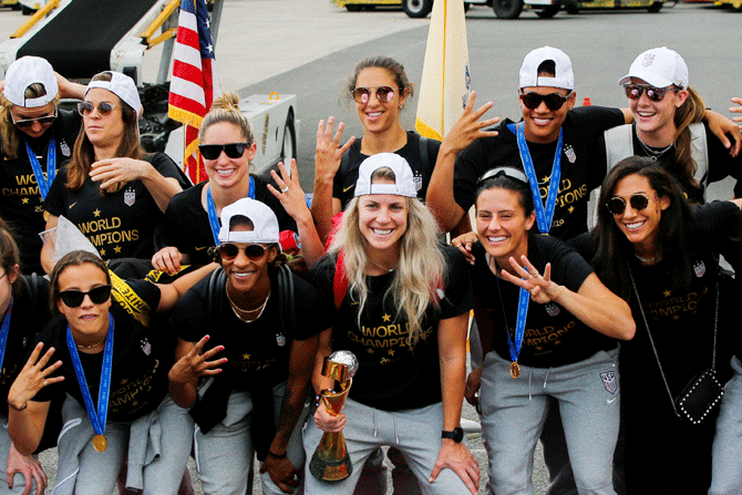 USA's women soccer players celebrate as they arrive at the Newark International Airport with the trophy for the FIFA Women's World Cup, in Newark, New Jersey, US on Monday