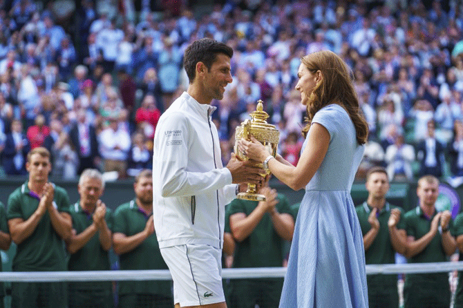 Her Royal Highness The Duchess of Cambridge, Kate Middleton presents Novak Djokovic the trophy after he defeated Roger Federer to win the Wimbledon title at the All England Lawn and Croquet Club on Sunday