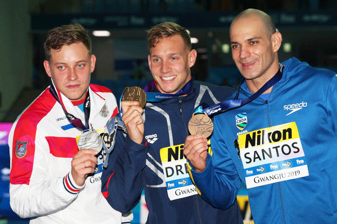 (Left-Right) Silver medalist Oleg Kostin of Russia, gold medalist Caeleb Dressel of the United States and bronze medalist Nicholas Santos of Brazil pose during the medal ceremony for the Men's 50m Butterfly Final