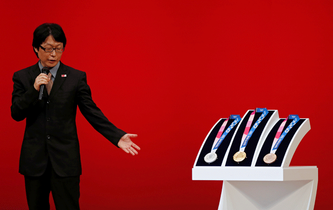 Medal designer Junichi Kawanishi speaks next to the design of the Tokyo 2020 Olympic medals as they are unveiled during the 'One Year to Go' ceremony celebrating one year out from the start of the summer games at Tokyo International Forum in Tokyo, Japan on Wednesday