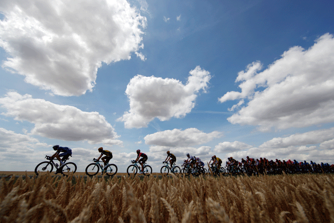 The peloton rides under a beautiful sky at the 215-km Stage 3 from Binche to Epernay on July 8